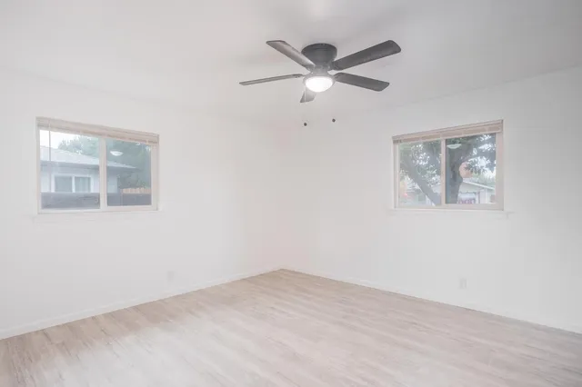 a view of a big room with wooden floor closet and windows