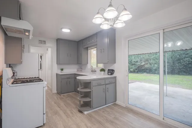 a kitchen that has a lot of cabinets and wooden floor