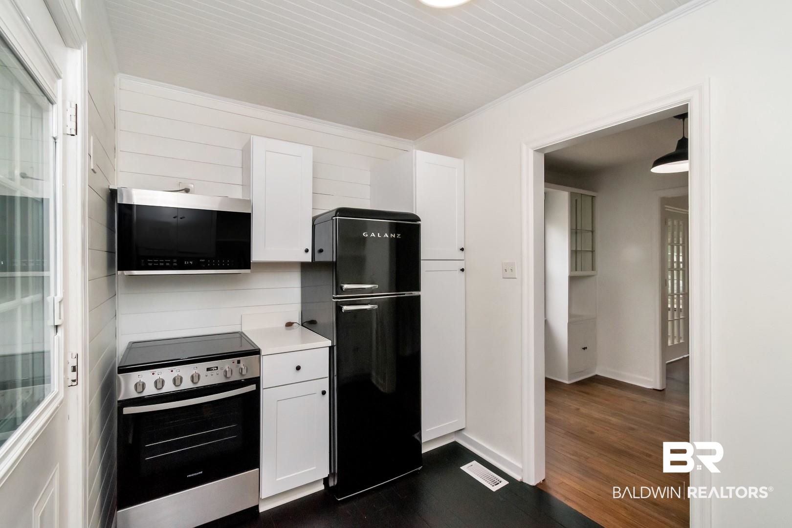 208 Morgan Avenue Mobile, AL 36606 - Photo 12 of 27 Kitchen with appliances with stainless steel finishes, ornamental molding, dark hardwood / wood-style floors, and white cabinets