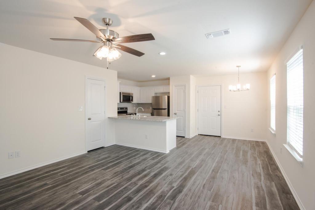 1516 Kennedy Street, Unit B Bonham, TX 75418 - Photo 4 of 11 a view of a kitchen with wooden floor and a ceiling fan