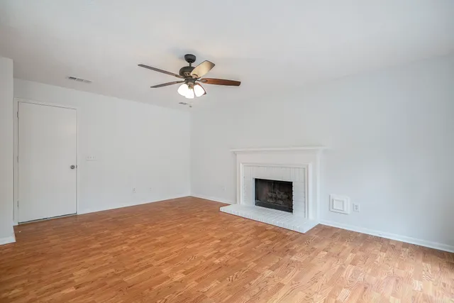 a view of empty room with fan and fireplace