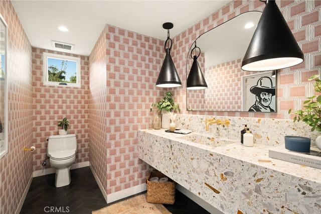 a bathroom with a sink toilet a mirror and vanity