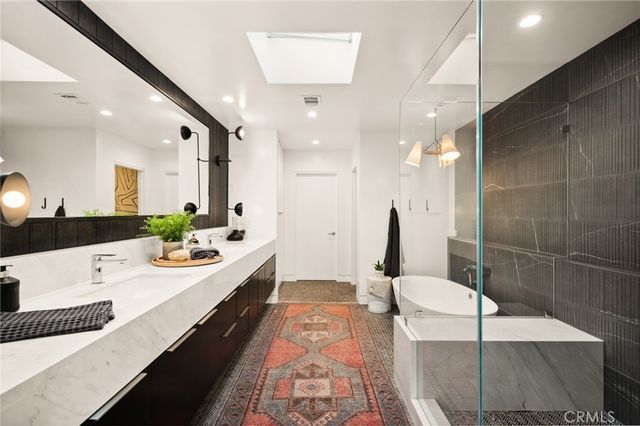 a large bathroom with a double vanity sink a toilet and a mirror