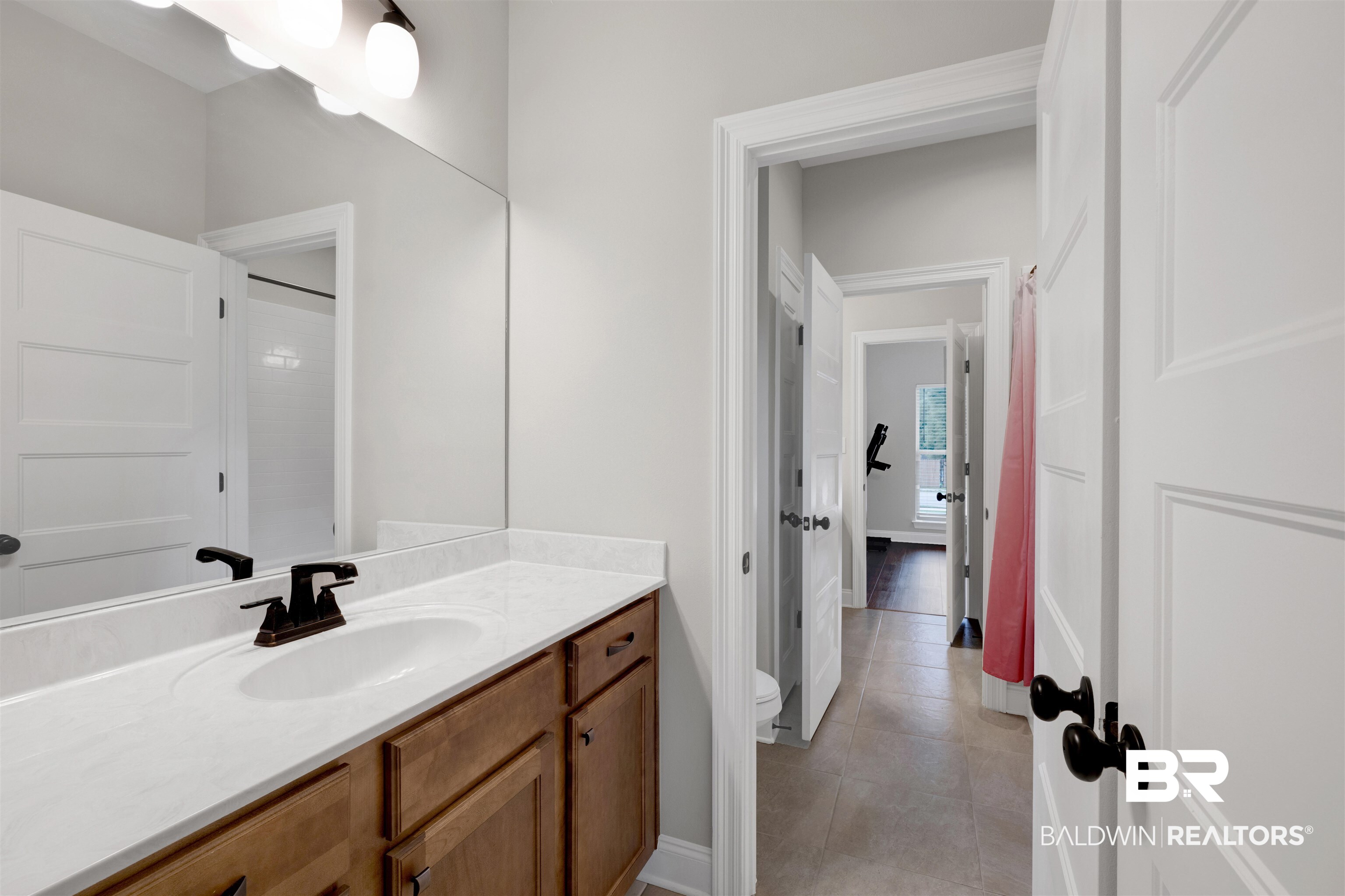 12672 Squirrel Drive Daphne, AL 36527 - Photo 32 of 49 Bathroom vanity featuring a single basin, dark bronze faucet, and light-toned countertop