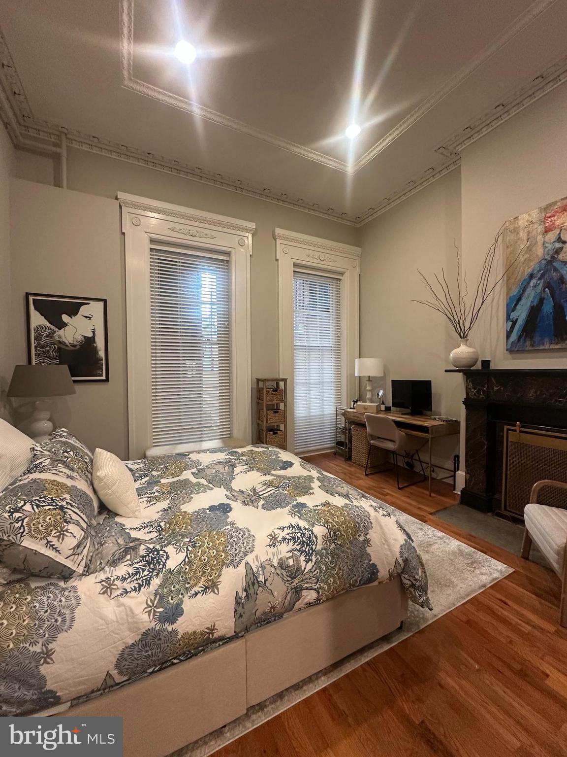 1015 Clinton Street, Unit 1F Philadelphia, PA 19107 - Photo 11 of 17 a bedroom with a bed a fireplace and dresser