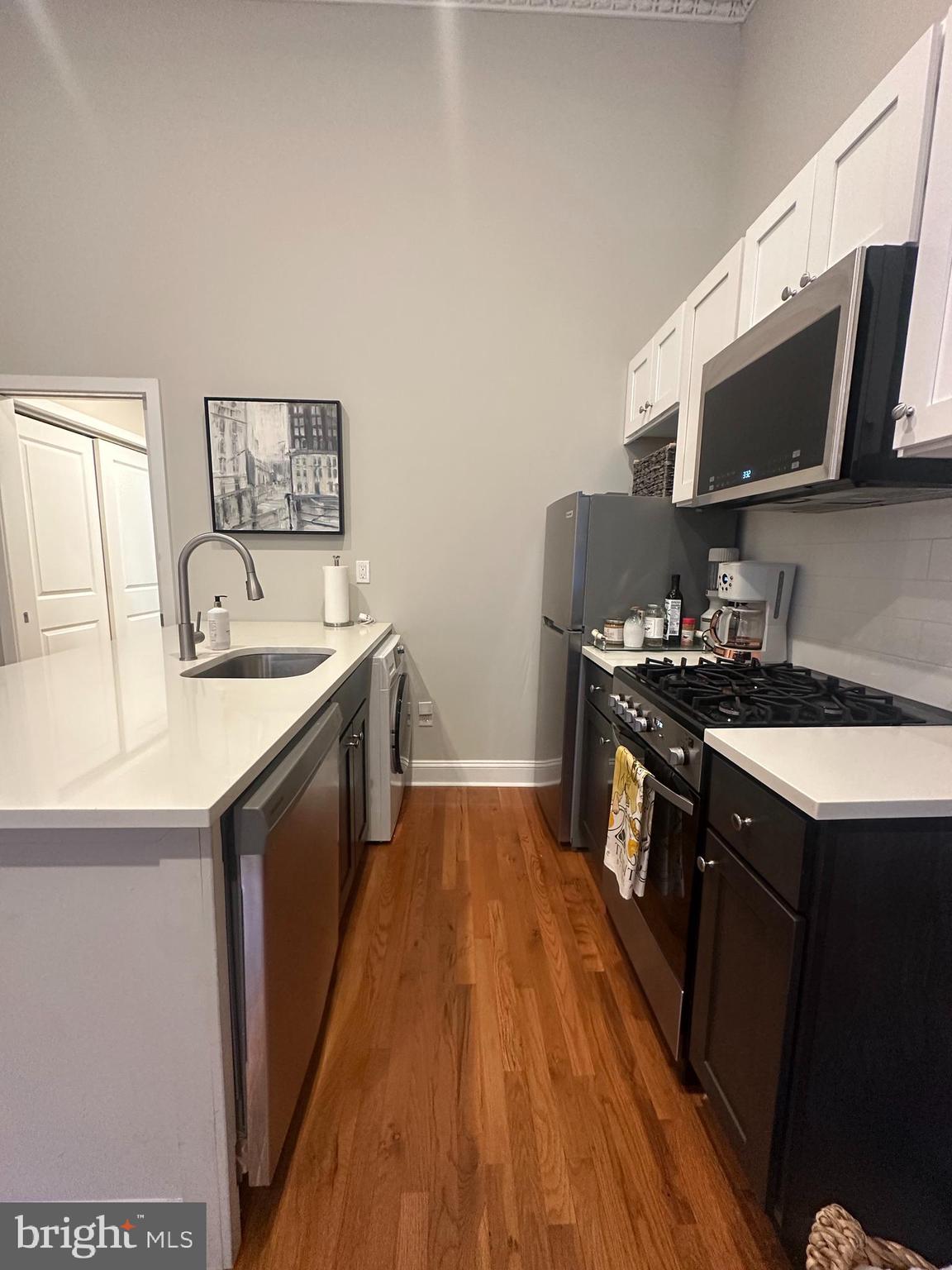 1015 Clinton Street, Unit 1F Philadelphia, PA 19107 - Photo 6 of 17 a kitchen with stainless steel appliances granite countertop a sink stove and microwave