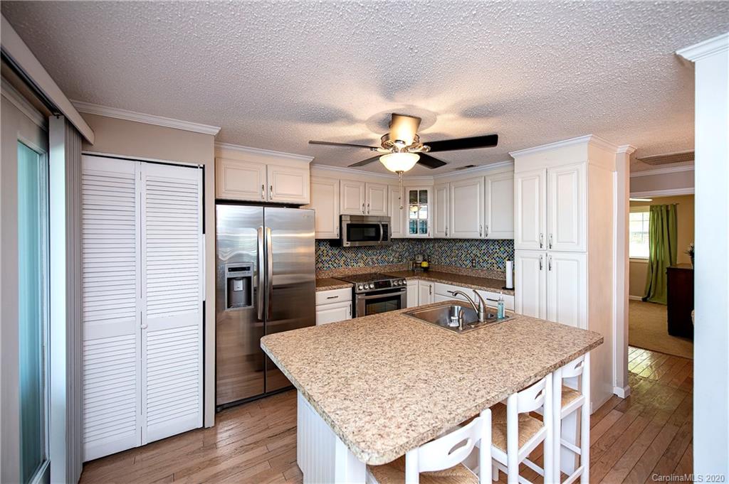 817 Bonum Road Lake Wylie, SC 29710 - Photo 21 of 41 a kitchen with stainless steel appliances granite countertop a kitchen island a stove a refrigerator a sink a dining table and chairs