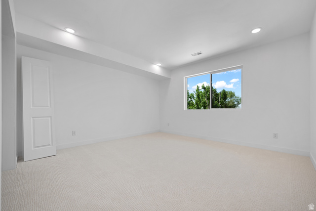 7238 South 525 East Midvale, UT 84047 - Photo 18 of 29 Bright room featuring a large window, plush carpet flooring, recessed lighting, and a paneled door