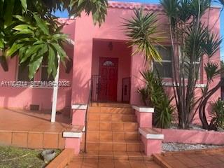 a palm tree sitting in front of a house