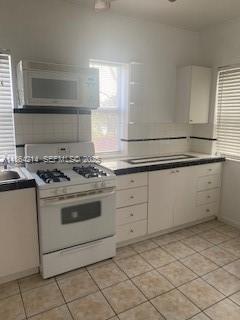 1537 Southwest 1st Street, Unit 2 Miami, FL 33135 - Photo 4 of 10 a kitchen with granite countertop white cabinets and white appliances