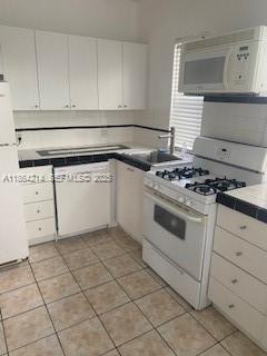 1537 Southwest 1st Street, Unit 2 Miami, FL 33135 - Photo 5 of 10 a kitchen with white cabinets and appliances