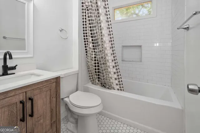 a bathroom with a granite countertop sink a toilet and shower