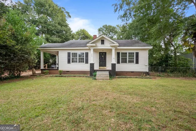 a front view of house with yard and trees