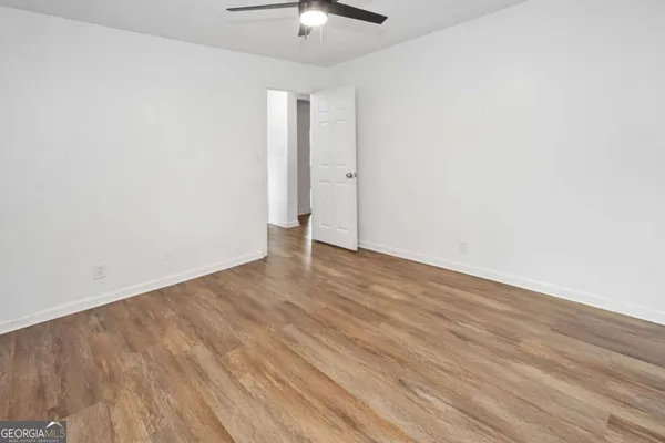 a view of an empty room with wooden floor