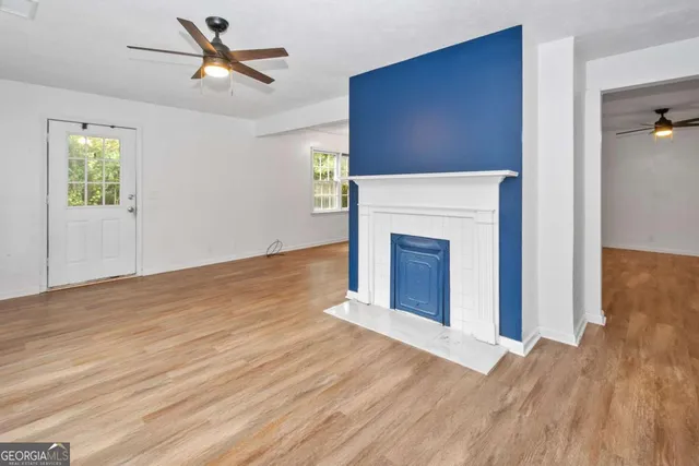 a view of a livingroom with wooden floor and a fireplace