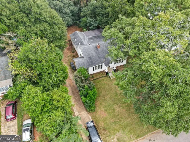 an aerial view of residential house with outdoor space and trees all around