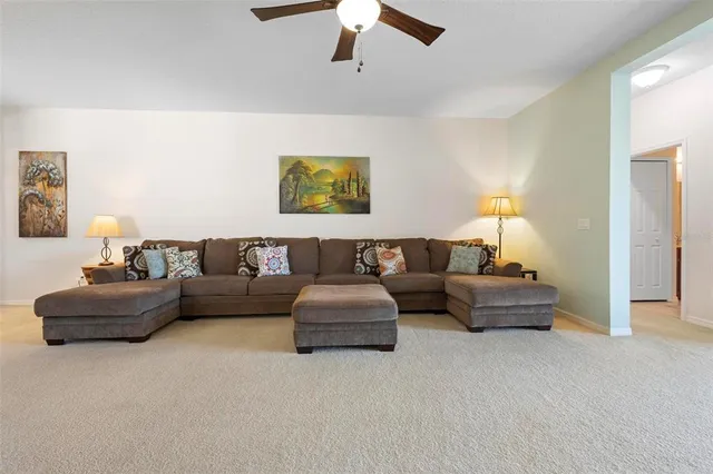 a living room with furniture and a ceiling fan