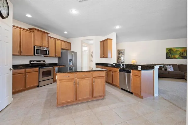 a kitchen with stainless steel appliances granite countertop a stove sink and cabinets