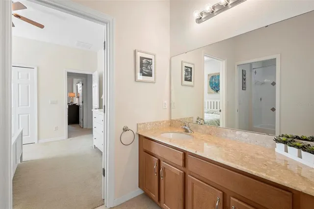 a bathroom with a granite countertop white tub shower and toilet