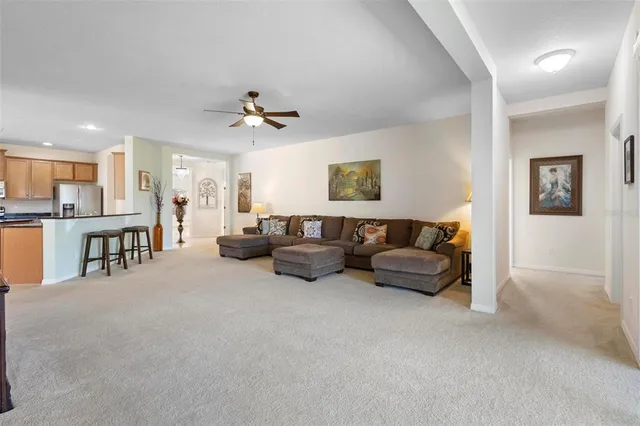 a living room with furniture and a view of kitchen