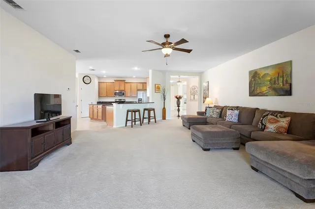a living room with furniture a flat screen tv and kitchen view