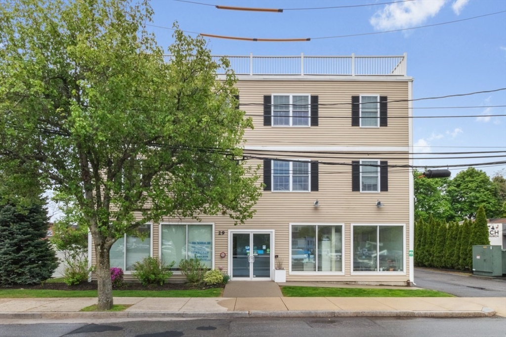 29 Spruce Street, Unit 23 Waltham, MA 02453 - Photo 2 of 26 a front view of a house with a garden