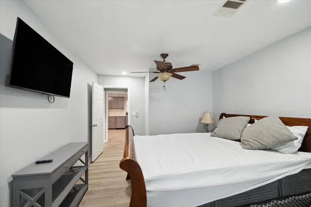 a bedroom with a bed and a flat tv screen on wall