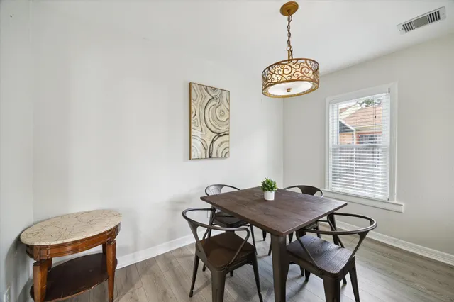 a view of a dining room with a table and chairs