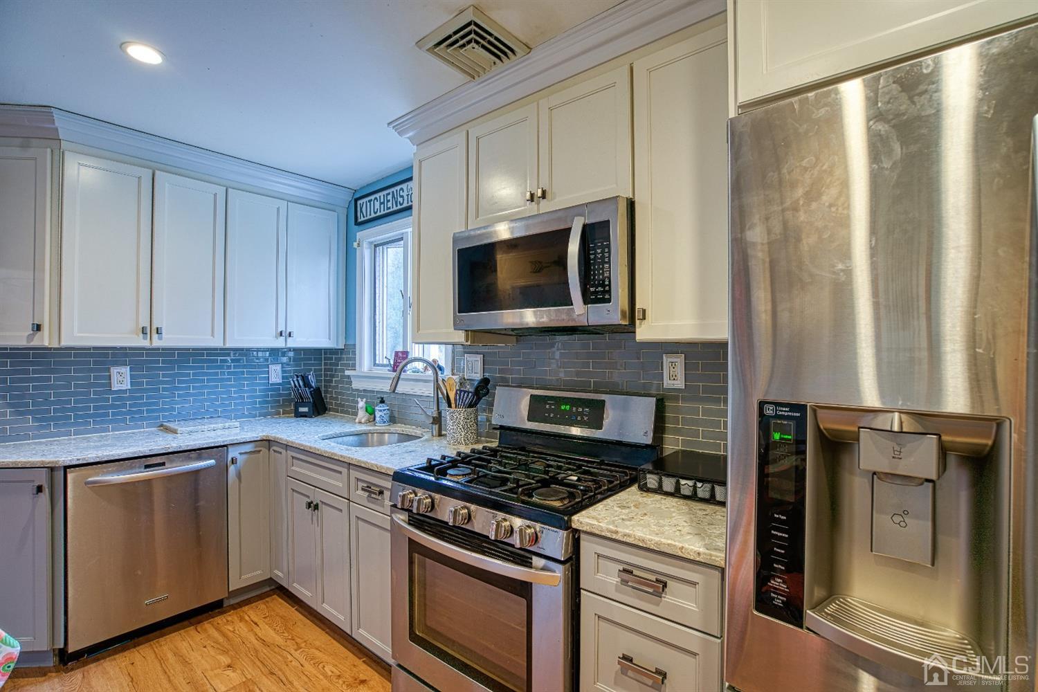 8 Clausen Road Edison, NJ 08817 - Photo 6 of 17 a kitchen with granite countertop a stove top oven microwave and cabinets
