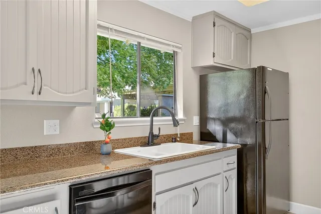 a kitchen with granite countertop a sink and a refrigerator
