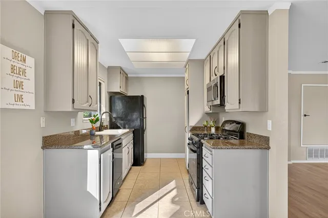 a kitchen with stainless steel appliances granite countertop a sink stove and cabinets