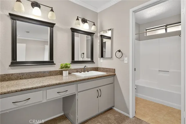 a bathroom with a granite countertop sink mirror and