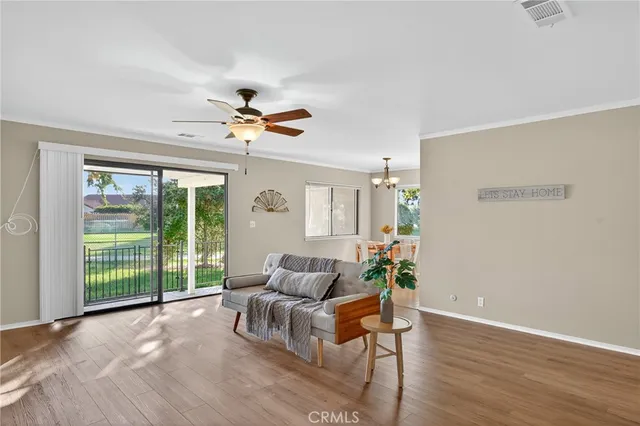 a living room with furniture and a large window with wooden floor