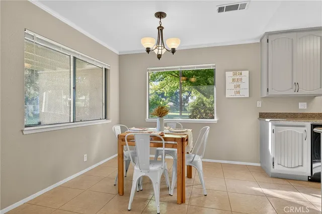 a dining room with wooden floor a chandelier a wooden table and chairs