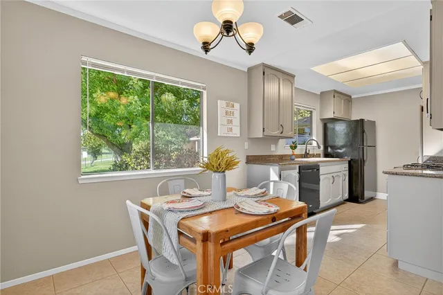 a kitchen with stainless steel appliances granite countertop a stove a refrigerator a sink dishwasher a dining table and chairs with wooden floor