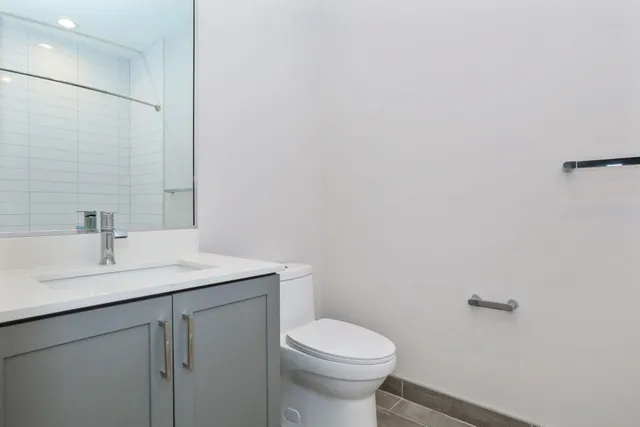 a bathroom with a sink a toilet and mirror
