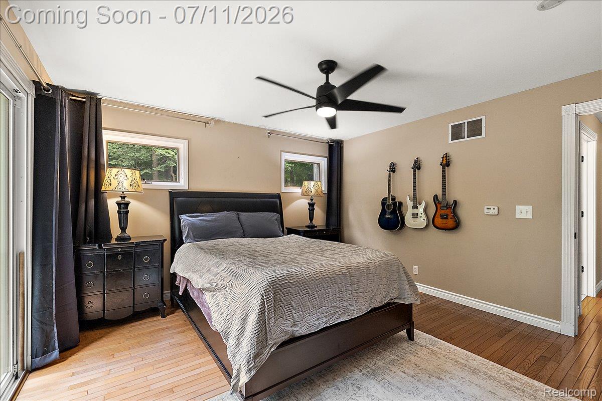 4219 Gardner Road Metamora, MI 48455 - Photo 36 of 87 Bedroom featuring wood-finish flooring, a contemporary ceiling fan, and two windows