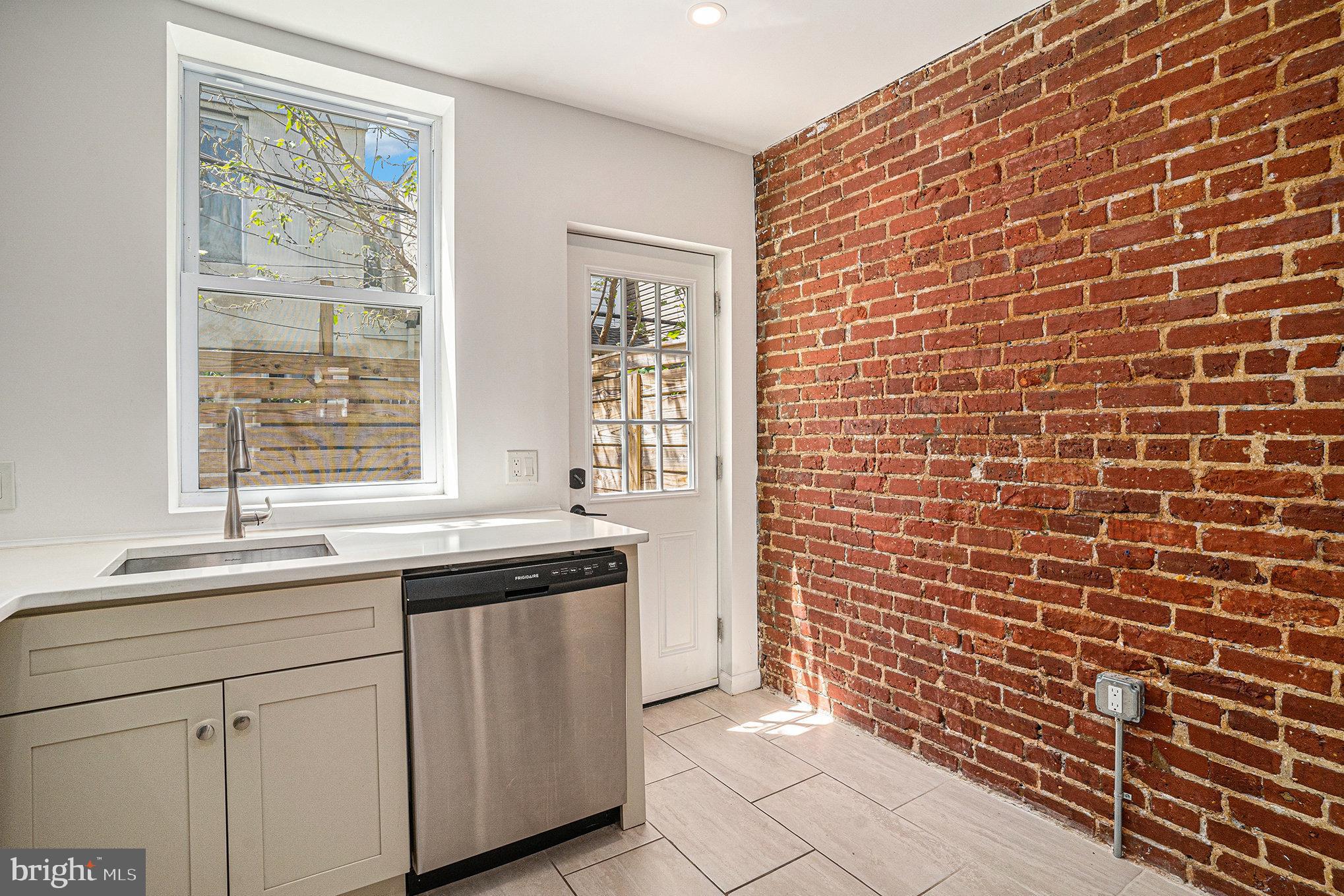 2128 Fernon Street Philadelphia, PA 19145 - Photo 13 of 30 a kitchen with a sink cabinets and window