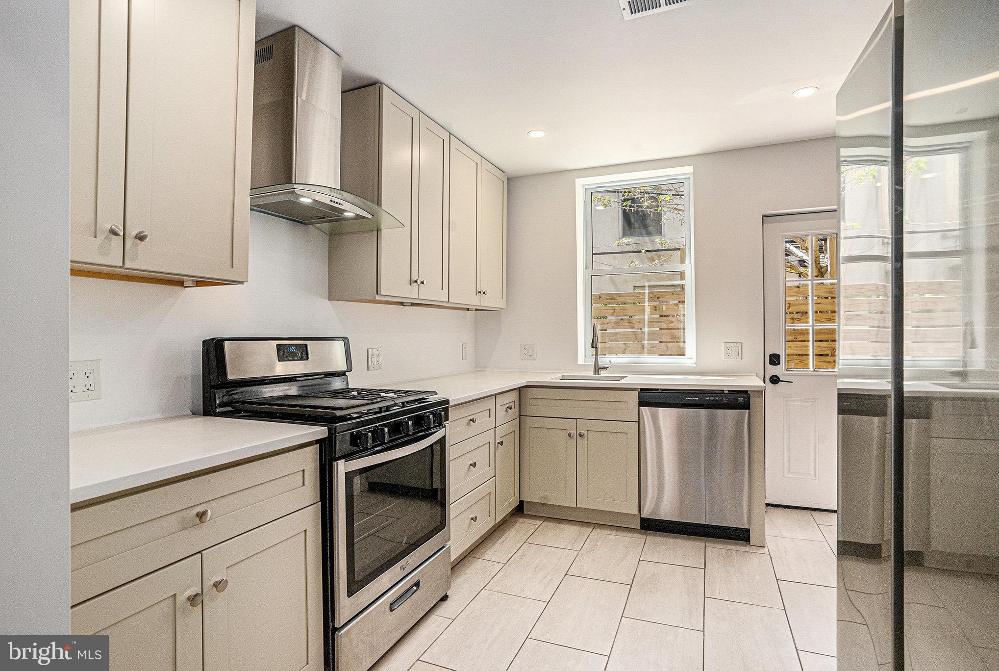 2128 Fernon Street Philadelphia, PA 19145 - Photo 10 of 30 a kitchen with granite countertop white cabinets and white appliances