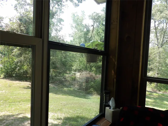 a view of a chair and tables in the patio along the house