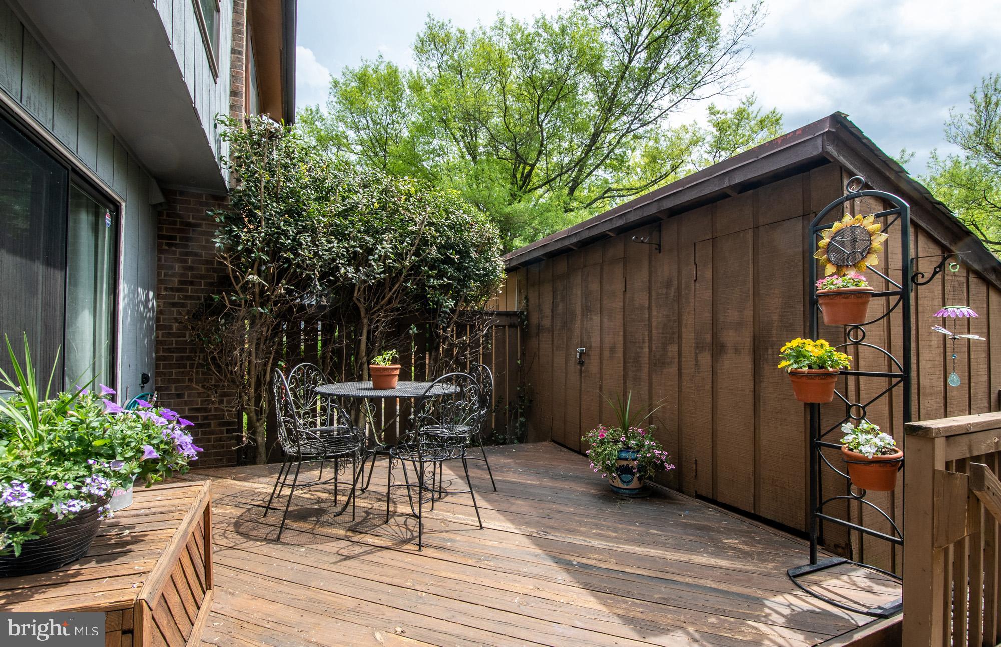a view of backyard with a table and chairs and potted plants