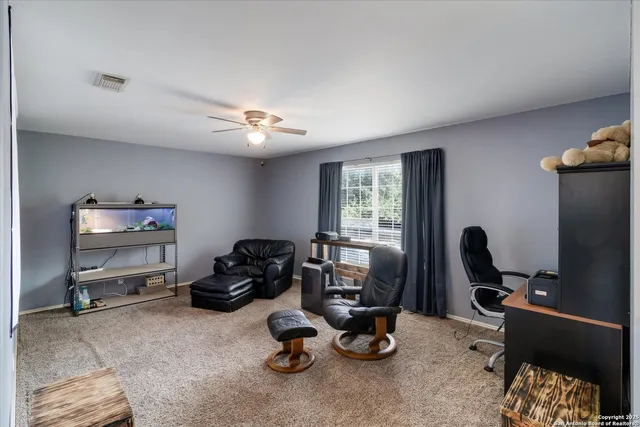 a view of a workspace with furniture and a window