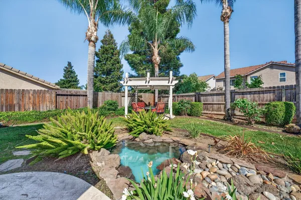 a view of a house with a yard and potted plants