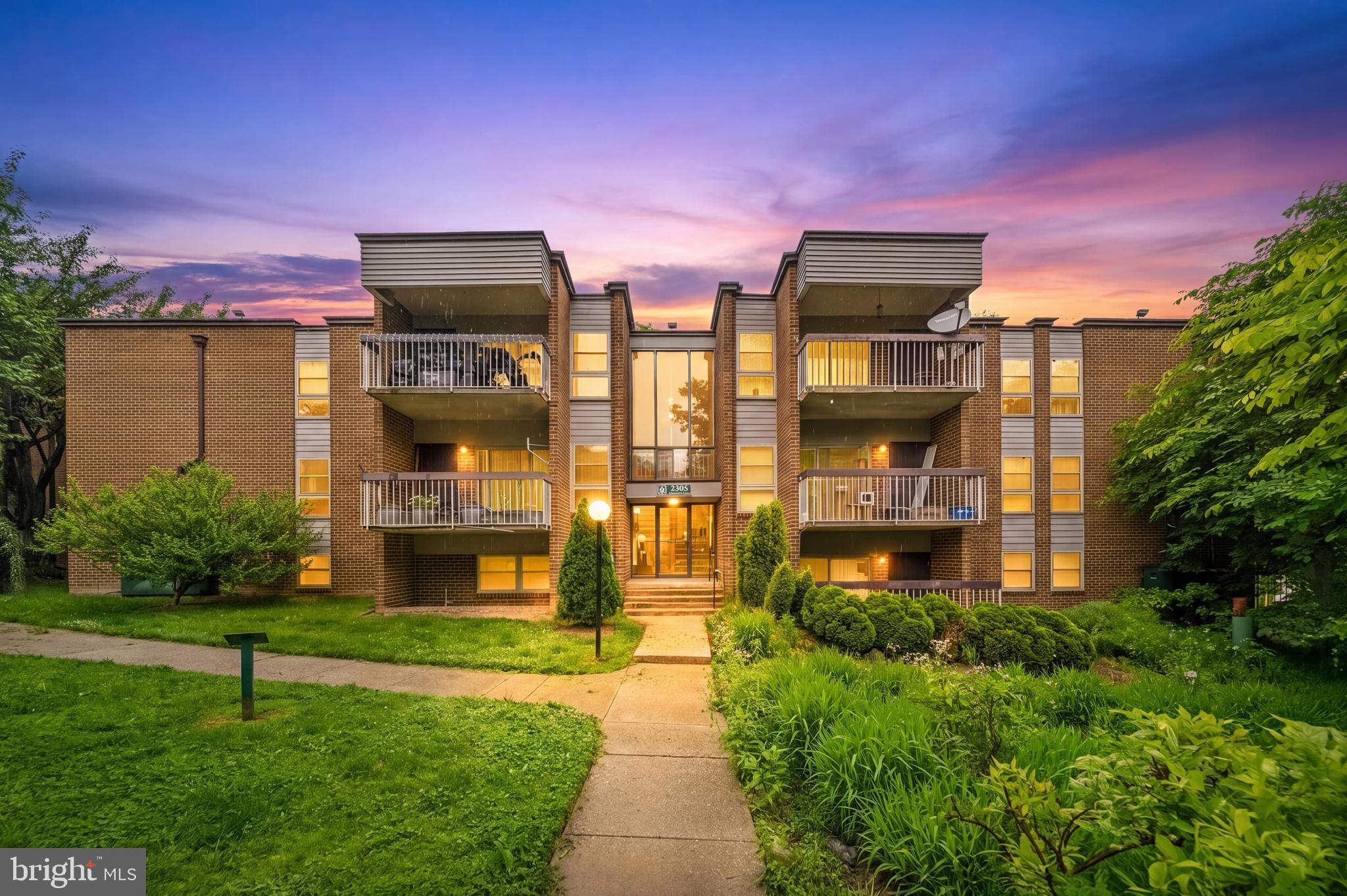 2305 Greenery Lane, Unit T23 Silver Spring, MD 20906 - Photo 2 of 40 a front view of a multi story residential apartment building with yard and retail shops
