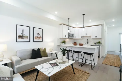 a living room with stainless steel appliances kitchen island furniture and a dining table