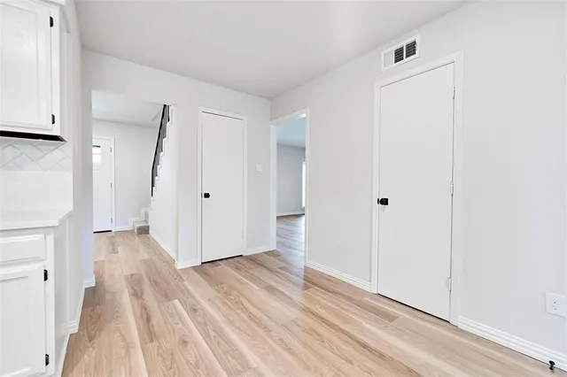 a view of a hallway with wooden floor and entryway