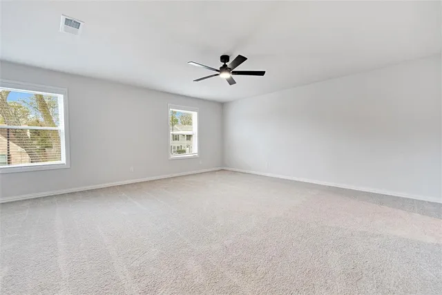 an empty room with a window and a ceiling fan