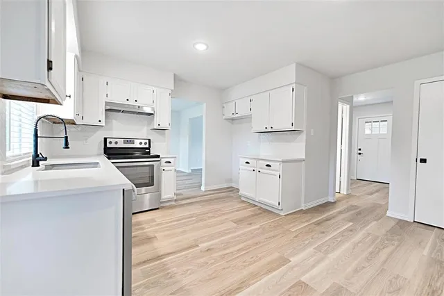 a kitchen with white cabinets and stainless steel appliances