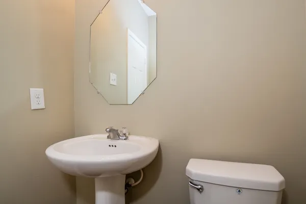 a bathroom with a toilet a sink and mirror