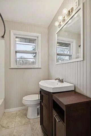 a bathroom with a sink a toilet and mirror